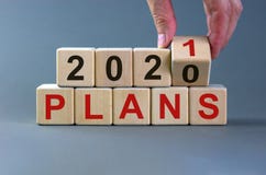 Business concept of planning 2021. Male hand flips wooden cube and change the inscription `Plans 2020` to `Plans 2021`. Beauti