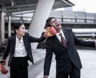 Business concept : Young Asian business woman in suit uniform wearing boxing gloves and punching business man`s face. stock photos Business concept : Young Asian business woman in suit uniform wearing boxing gloves and punching business man`s face. stock photos