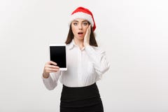 Business Concept - young caucasian business woman in Christmas theme showing digital tablet with surprising facial stock photo Business Concept - young caucasian business woman in Christmas theme showing digital tablet with surprising facial stock photo