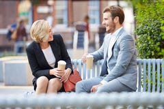 Business Couple On Park Bench With Coffee