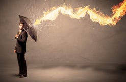 Business man defending himself from a fire arrow with an umbrella Stock Photo Business man defending himself from a fire arrow with an umbrella Stock Photo