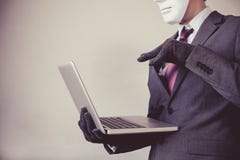 Business man in white mask wearing gloves and using computer - fraud, hacker, theft, cyber crime royalty free stock photo Business man in white mask wearing gloves and using computer - fraud, hacker, theft, cyber crime royalty free stock photo