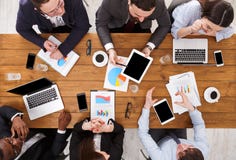 Business meeting. Multiethnic emploees team discuss the report in office, top view of wooden table Royalty Free Stock Photos Business meeting. Multiethnic emploees team discuss the report in office, top view of wooden table Royalty Free Stock Photos