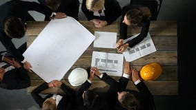 Business people with construction blueprint