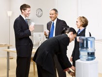 Business people drinking water at water cooler stock images Business people drinking water at water cooler stock images