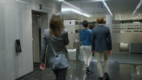 Business people exiting lift car in corridor. Businessman hurry for meeting
