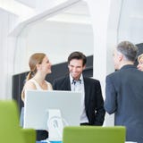 Business people having smalltalk in office stock photo Business people having smalltalk in office stock photo