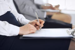 Business people taking part at conference or training at office, close-up. Women sitting on chairs and making notes like stock photo Business people taking part at conference or training at office, close-up. Women sitting on chairs and making notes like stock photo