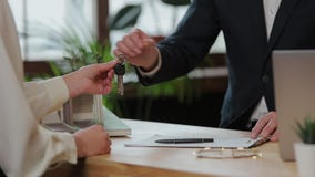 Business, real estate, deal and people concept - man giving house keys to woman at office. stock video Business, real estate, deal and people concept - man giving house keys to woman at office. stock video