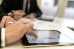 Business team using tablet computer to work with financial data stock photos Business team using tablet computer to work with financial data stock photos