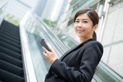Business woamn holding cellphone and standing at escalator stock images Business woamn holding cellphone and standing at escalator stock images