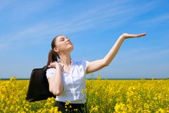 Business woman with briefcase relaxing in flower field outdoor under sun. Young girl in yellow rapeseed field. Beautiful spring la Stock Photos Business woman with briefcase relaxing in flower field outdoor under sun. Young girl in yellow rapeseed field. Beautiful spring la Stock Photos