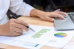 Business woman holding pen in hand working with financial paper charts and laptop computer royalty free stock photos Business woman holding pen in hand working with financial paper charts and laptop computer royalty free stock photos