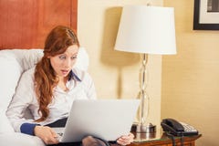 Business woman using laptop looking at computer screen blown away in stupor