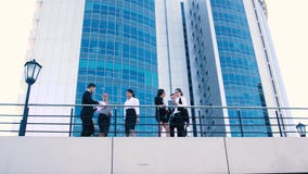 Business women and business men talking on terrace. From below shot stock video Business women and business men talking on terrace. From below shot stock video
