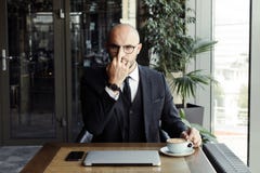 Businessman in a black suit adjusts his glasses with his finger stock photography Businessman in a black suit adjusts his glasses with his finger stock photography