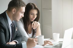 Businessman and businesswoman at office desk, looking at the lap royalty free stock photos Businessman and businesswoman at office desk, looking at the lap royalty free stock photos