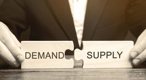 Businessman collects wooden puzzles with the word Demand and Supply. The concept of the labor market. Economic theory, stock images Businessman collects wooden puzzles with the word Demand and Supply. The concept of the labor market. Economic theory, stock images