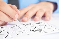 Businessman drawing bar chart and other infographics in note pad