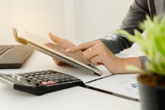 Businessman with finger touching screen of a digital tablet at office on table with document graph data stock images Businessman with finger touching screen of a digital tablet at office on table with document graph data stock images