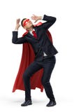 A businessman in a hero red cape and a mask in front view crouching in fear on white background. stock photography A businessman in a hero red cape and a mask in front view crouching in fear on white background. stock photography