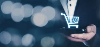 Businessman holding a phone with a shopping icon. Online shopping stock photo Businessman holding a phone with a shopping icon. Online shopping stock photo