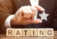Businessman holds one star above the wooden blocks with the word Rating. Concept of negative feedback. Low quality and service royalty free stock images Businessman holds one star above the wooden blocks with the word Rating. Concept of negative feedback. Low quality and service royalty free stock images
