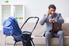 The businessman looking after newborn baby at home and teleworking Royalty Free Stock Photo The businessman looking after newborn baby at home and teleworking Royalty Free Stock Photo