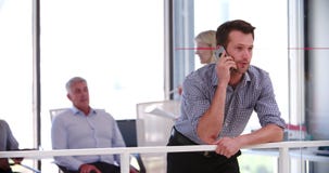 Businessman On Mobile Phone Outside Meeting Room