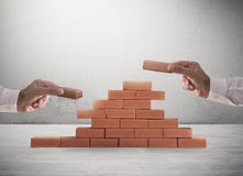 Businessman puts a brick to build a wall. Concept of new business, partnership, integration and startup royalty free stock photo Businessman puts a brick to build a wall. Concept of new business, partnership, integration and startup royalty free stock photo