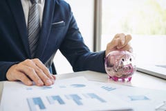 Businessman putting coins into piggy bank and using calculator t Royalty Free Stock Images Businessman putting coins into piggy bank and using calculator t Royalty Free Stock Images