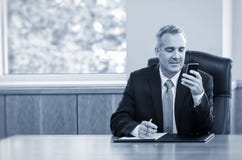 Businessman reading text messages on his phone stock image Businessman reading text messages on his phone stock image