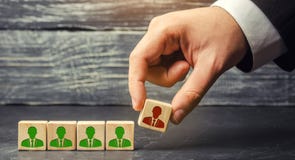The businessman removes / dismisses the employee from the team. management within the team. wooden blocks with a picture of worker royalty free stock images The businessman removes / dismisses the employee from the team. management within the team. wooden blocks with a picture of worker royalty free stock images