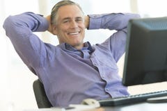Businessman Sitting With Hands Behind Head At Office Desk Royalty Free Stock Photos Businessman Sitting With Hands Behind Head At Office Desk Royalty Free Stock Photos