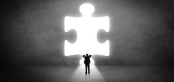 Businessman standing in front of a big puzzle piece Stock Image Businessman standing in front of a big puzzle piece Stock Image