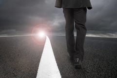 Businessman walking on asphalt road with sunlight cloudy sky royalty free stock photo Businessman walking on asphalt road with sunlight cloudy sky royalty free stock photo