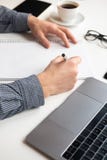 Businessman writing in notebook. White table with coffee laptop, glasses royalty free stock photo Businessman writing in notebook. White table with coffee laptop, glasses royalty free stock photo