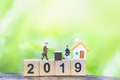 Businessmans und Haus auf Holzklotznummerjahr 2019 auf Gr?nnaturhintergrund stockbilder Businessmans und Haus auf Holzklotznummerjahr 2019 auf Gr?nnaturhintergrund stockbilder