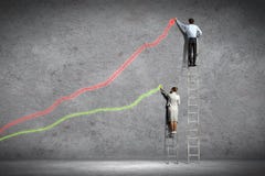 Businesspeople drawing diagrams on wall stock photo Businesspeople drawing diagrams on wall stock photo