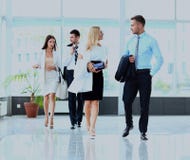 Businesspeople grupperar att gå på den moderna ljusa kontorsinre arkivbild Businesspeople grupperar att gå på den moderna ljusa kontorsinre arkivbild
