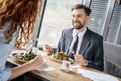 Businesspeople som har affärslunch på restaurangen som sitter äta sallad som diskuterar glat arbete royaltyfri bild Businesspeople som har affärslunch på restaurangen som sitter äta sallad som diskuterar glat arbete royaltyfri bild