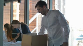 Businesspeople unpacking boxes and looking at road drawings in modern office. stock video footage Businesspeople unpacking boxes and looking at road drawings in modern office. stock video footage