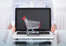 Businessperson med den shoppingvagnen och bärbara datorn arkivbilder Businessperson med den shoppingvagnen och bärbara datorn arkivbilder