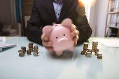 Businessperson`s Hand Shaking Piggy Bank stock photography Businessperson`s Hand Shaking Piggy Bank stock photography