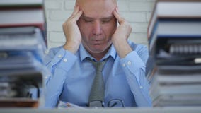 Businessperson Working Late In Office Room Suffering Big Headache stock photo Businessperson Working Late In Office Room Suffering Big Headache stock photo