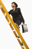 Businesswoman climbing ladder.