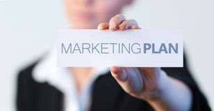 Businesswoman holding a label with marketing plan written on it