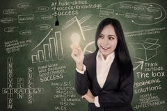 Businesswoman holds lit bulb in class Stock Photo Businesswoman holds lit bulb in class Stock Photo