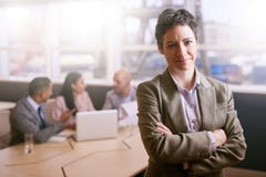 Businesswoman smiling at the camera in front of her colleagues royalty free stock photography Businesswoman smiling at the camera in front of her colleagues royalty free stock photography