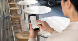 Businesswoman taking picture with mobile phone in coffee shop stock images Businesswoman taking picture with mobile phone in coffee shop stock images